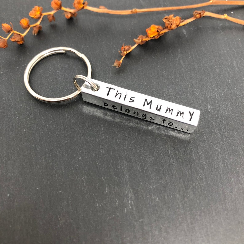 May include: Silver keychain with a rectangular charm that reads "This Mummy belongs to..."