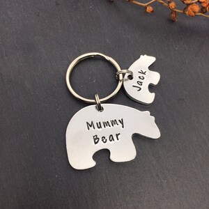 Puede incluir: Llaveros de plata con forma de oso con el texto "Mummy Bear" y "Jack" grabados en ellos. Los llaveros est&aacute;n unidos a un llavero de plata.