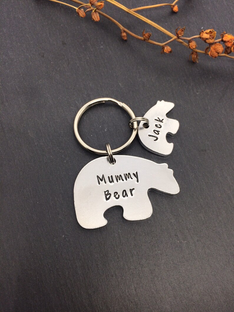 Puede incluir: Llaveros de plata con forma de oso con el texto "Mummy Bear" y "Jack" grabados en ellos. Los llaveros est&aacute;n unidos a un llavero de plata.