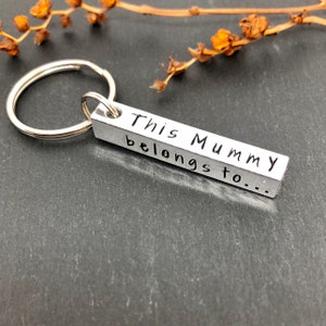 May include: Silver keychain with a rectangular tag that reads "This Mummy belongs to..."