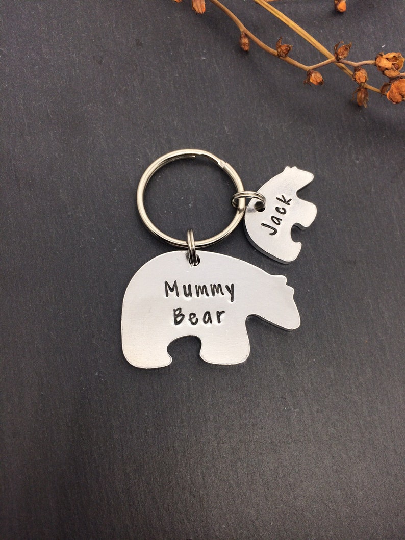 Puede incluir: Un llavero de plata con dos dijes en forma de oso. El dije m&aacute;s grande dice "Mummy Bear" y el dije m&aacute;s peque&ntilde;o dice "Jack".