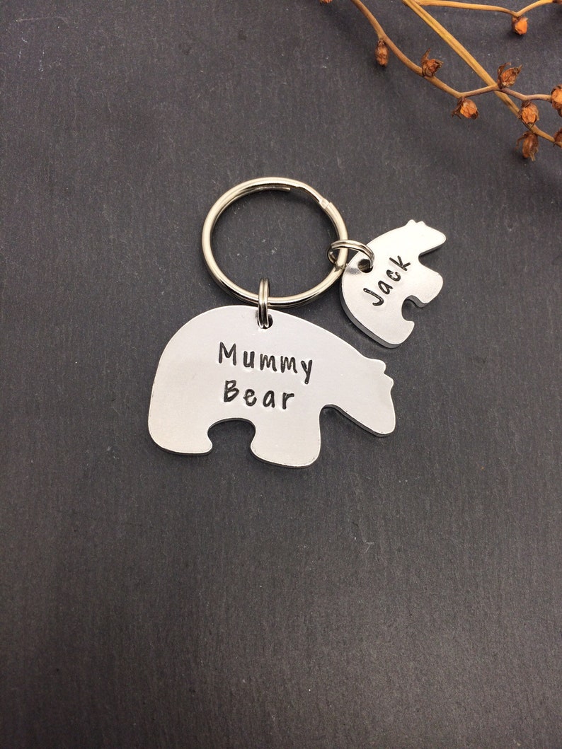 Puede incluir: Un llavero de plata con dos dijes en forma de oso polar. El dije m&aacute;s grande dice "Mummy Bear" y el dije m&aacute;s peque&ntilde;o dice "Jack".