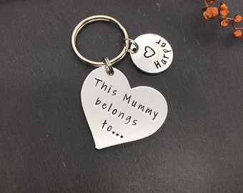 May include: Silver heart-shaped keyring with the text "This belongs to... Mummy" and a smaller round charm with the text "Love Harper".