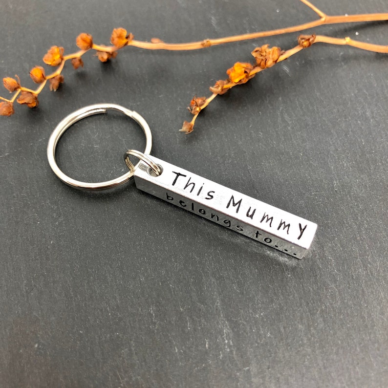 May include: Silver keychain with a rectangular tag that reads "This Mummy belongs to..."