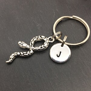 May include: Silver snake keyring with a round silver charm with the letter J engraved on it.