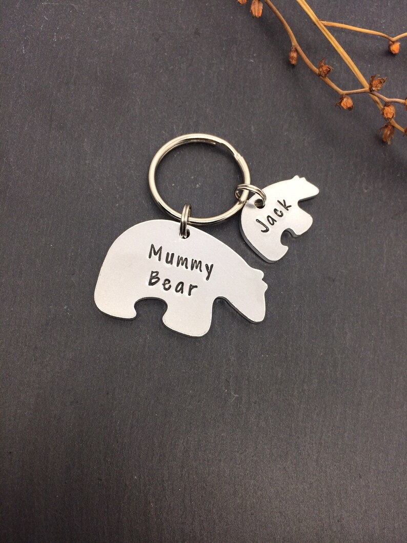Puede incluir: Llavero de plata con dos dijes en forma de oso polar. El dije m&aacute;s grande dice "Mummy Bear" y el dije m&aacute;s peque&ntilde;o dice "Jack".