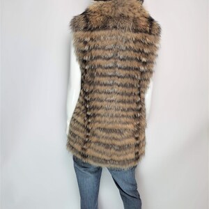 May include: A brown and black striped fur vest with a large fur collar. The vest is sleeveless and has a long, straight cut.