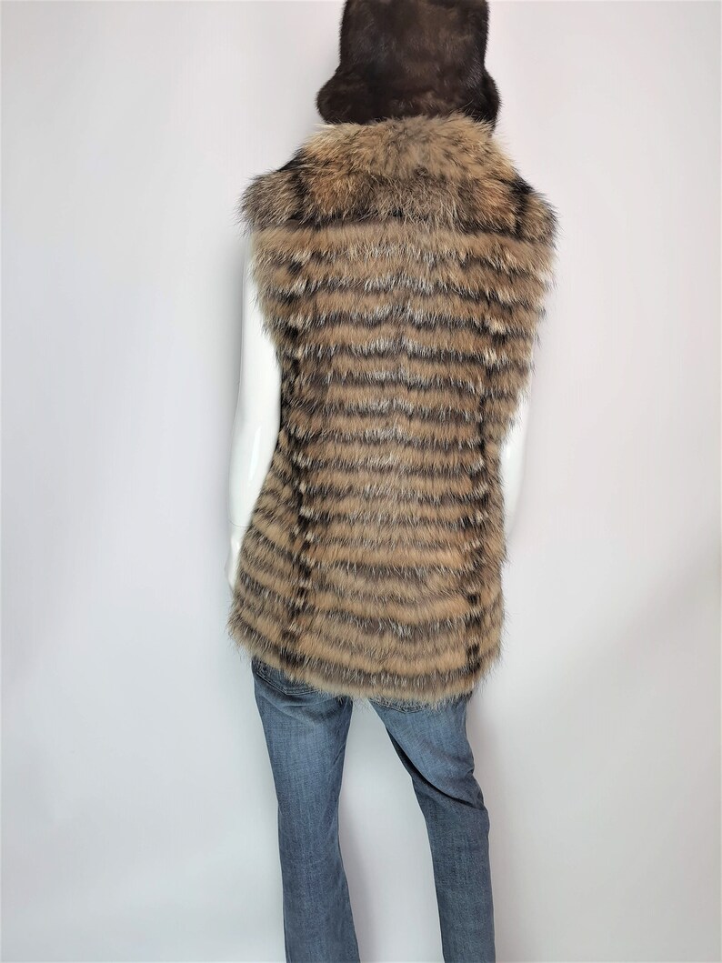 May include: A brown and black striped fur vest with a large fur collar. The vest is sleeveless and has a long, straight cut.