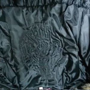 Pu&ograve; includere: Fodera nera trapuntata di un cappotto di pelliccia. La fodera &egrave; liscia e presenta un motivo trapuntato.