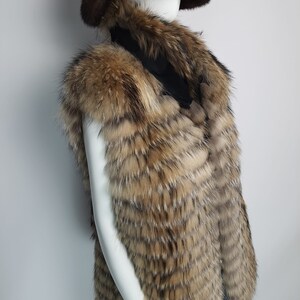 May include: A brown and tan fur vest with a long, pointed collar. The vest is made of a soft, luxurious fur and has a sleek, modern design.