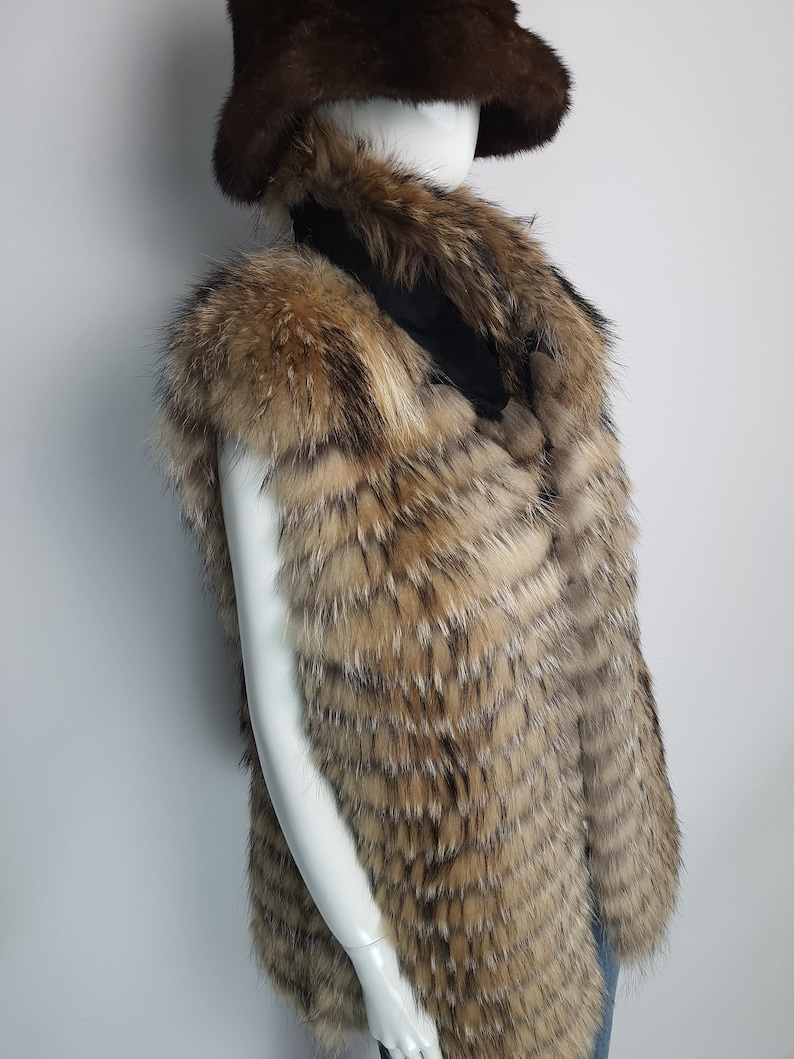 May include: A brown and tan fur vest with a long, pointed collar. The vest is made of a soft, luxurious fur and has a sleek, modern design.