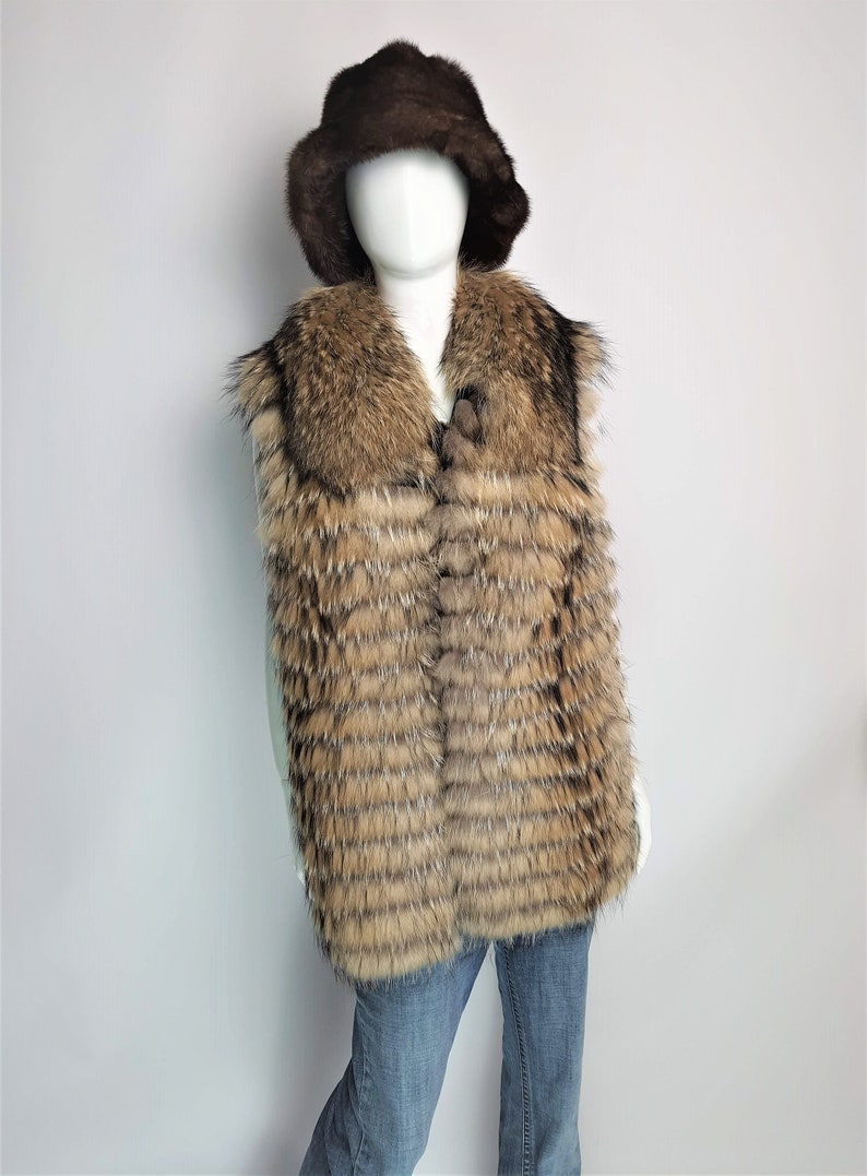 May include: A brown fur vest with a large collar and a brown fur hat. The vest is made of long, thin strips of fur that are sewn together in a horizontal pattern.