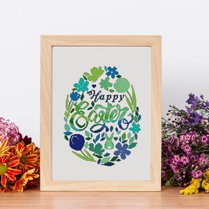 Puede incluir: Un diseño de punto de cruz enmarcado que presenta una corona floral colorida con el texto "Happy Easter" en el centro. La corona está compuesta por flores y hojas verdes, azules y moradas.