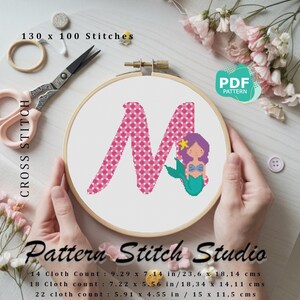 Puede incluir: Patrón de punto de cruz para la letra M con un diseño de sirena. El patrón está disponible en formato PDF e incluye instrucciones para telas Aida de 14, 18 y 22 puntos. El patrón mide 130 puntos de ancho por 100 puntos de alto.
