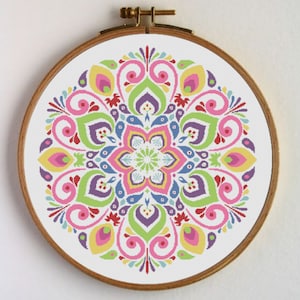 Puede incluir: Un patrón de punto de cruz de mandala colorido con tonos rosas, amarillos, verdes, azules y morados. El diseño presenta intrincados motivos florales y geométricos.