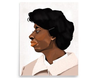 May include: A digital illustration of a woman with short, dark hair. She is wearing a light brown jacket with a white collar and a white shirt underneath. The background is a light gray.