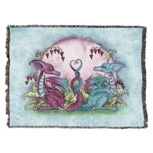May include: A woven tapestry featuring two dragons, one pink and one blue, with intertwined tails forming a heart shape. The dragons are surrounded by leafy vines and pink flowers against a light blue background.
