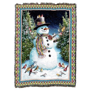 May include: A woven tapestry throw featuring a snowman with a black top hat, a colorful scarf, and a red flower. The snowman is surrounded by a snowy landscape with trees and birds.