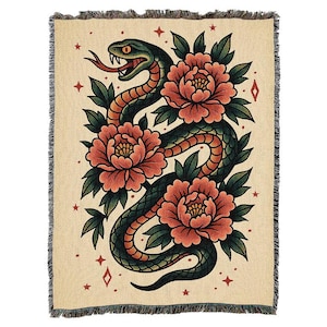 May include: Woven throw blanket with a design of a green snake and red peonies on a beige background. The blanket has a fringed edge and features red star and diamond accents. The design is reminiscent of traditional tattoo art.