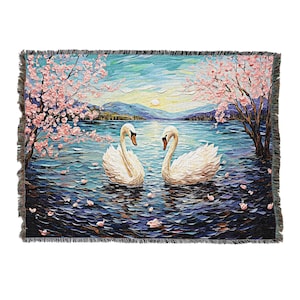 May include: A woven tapestry featuring two white swans swimming in a lake with pink cherry blossoms on the shore. The lake is a deep blue with purple and blue brushstrokes. The background is a hazy blue sky with a yellow sun.