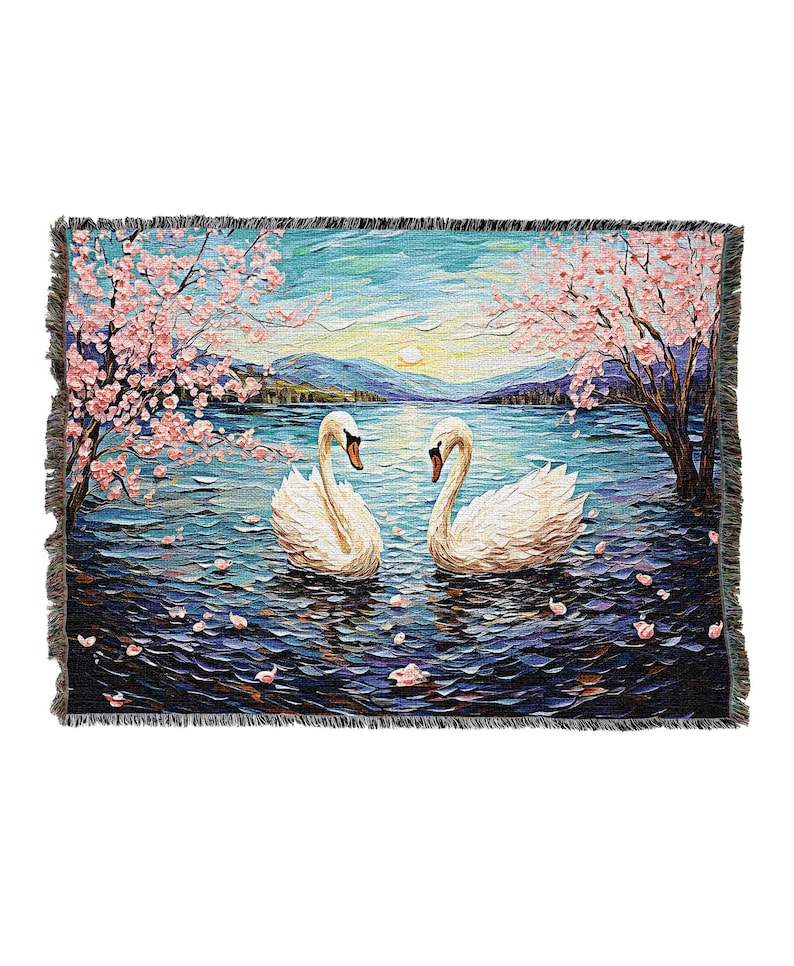 May include: A woven tapestry featuring two white swans swimming in a lake with pink cherry blossoms on the shore. The lake is a deep blue with purple and blue brushstrokes. The background is a hazy blue sky with a yellow sun.