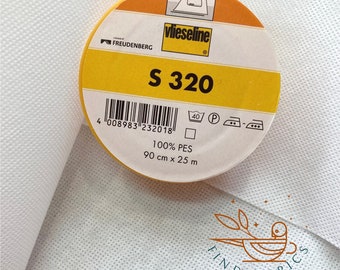 Peut inclure: Un rouleau d'entoilage thermocollant blanc étiqueté "vlieseline S 320" avec un code-barres, des instructions d'entretien et le texte "100% PES 90 cm x 25 m".