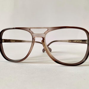 Op de afbeelding: Bruine plastic aviator-stijl bril met een dubbele brug.
