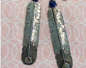 Brincos pendentes Kuticka em prata de lei com contas de lápis-lazúli azul e formato de pena.