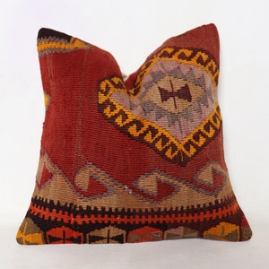 May include: Red, brown, yellow, and black patterned throw pillow with a geometric design.