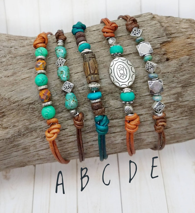 May include: Five leather bracelets with turquoise and brown beads, silver charms, and a variety of knots. The bracelets are labeled A through E.