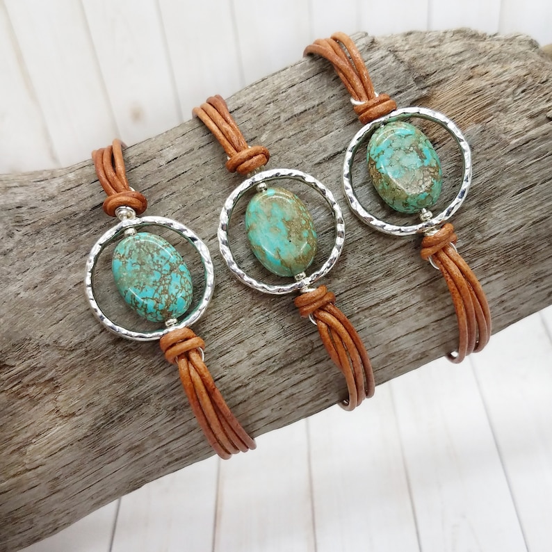 May include: Three brown leather bracelets with silver metal circles and turquoise oval stones.
