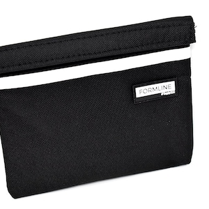 May include: Black zippered pouch with a white stripe and the word "FORMLINE" printed on the front.