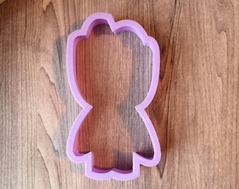 May include: Purple plastic cookie cutter shaped like a person with a rounded head, arms, and legs.