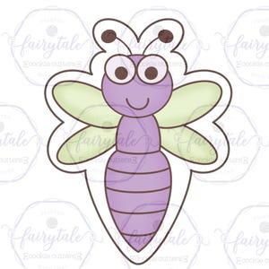 May include: A purple and green dragonfly cookie cutter with a smiling face and large eyes.