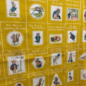 May include: Yellow fabric featuring illustrations from Beatrix Potter's children's books. Each square displays a different title and character, including Peter Rabbit, Squirrel Nutkin, and Mrs. Tittlemouse. The fabric has a repeating pattern of framed illustrations.