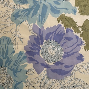Könnte beinhalten: Ein cremefarbener Stoff mit einem Blumenmuster. Die Blumen sind blau, lila und grün. Der Stoff hat einen Vintage-Look.