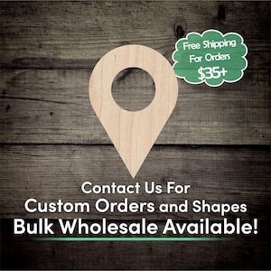 May include: A wooden map pin shape with a circular hole at the top, set against a dark wood grain background. The text "Contact Us For Custom Orders and Shapes Bulk Wholesale Available!" is displayed below the pin. A green cloud-shaped graphic reads "Free Shipping For Orders $35+".