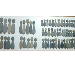 Può includere: Uno sfondo bianco con file di pietre grigie e bianche disposte a forma di persone. Le pietre sono di diverse dimensioni e forme.