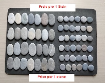 May include: A black mat with rows of smooth, gray stones. The text "Preis pro 1 Stein" and "Price per 1 stone" is printed on the mat.