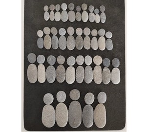 May include: A black background with a pattern of gray stones arranged in the shape of people. The stones are of varying sizes and shapes, creating a unique and interesting design.