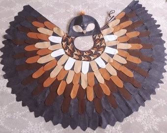 Puede incluir: Un disfraz de búho marrón, negro y blanco con una cabeza y alas de búho de fieltro. Las alas están hechas de fieltro y tienen un diseño en capas.