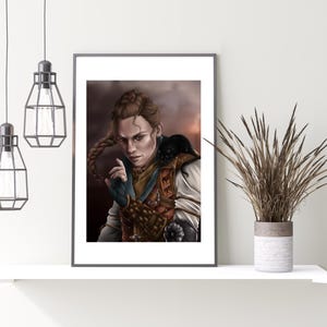 May include: Framed art print featuring a portrait of a person with a braided hairstyle, wearing a detailed costume with leather and metal accents. The artwork has a warm color palette with a focus on the subject's expression and pose. The print is displayed on a white shelf.
