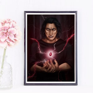 May include: Framed art print featuring a person with dark hair and a black shirt, holding a glowing red gem. Red lightning bolts emanate from the gem and surround the person, set against a dark red background.