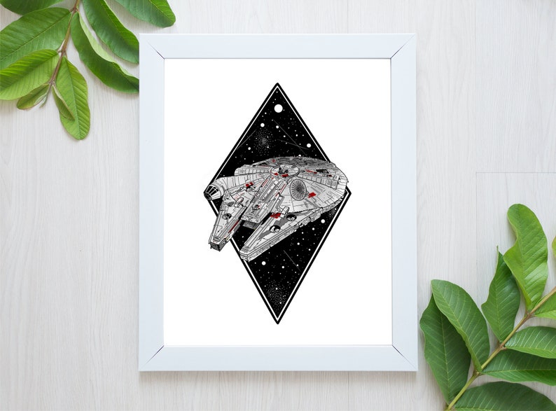 May include: White framed art print featuring a detailed illustration of the Millennium Falcon starship. The ship is set against a black diamond shape filled with stars. The artwork is in black, white, and red.