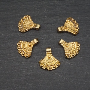 Könnte beinhalten: Fünf goldfarbene Metall-Anhänger mit einem fächerförmigen Design und filigranen Details. Jeder Anhänger hat eine kleine Öse oben zum Anbringen an einer Halskette oder einem Armband.