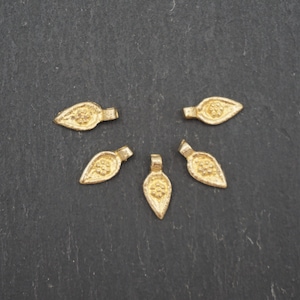 Könnte beinhalten: Fünf goldfarbene, metallene Anhänger in Blattform mit strukturierter Oberfläche. Die Anhänger haben eine kleine Öse oben zum Anbringen an Schmuck.