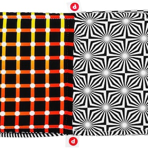 Puede incluir: Dos cuadrados de tela cosidos juntos para crear un panel de tela reversible. Un lado presenta un fondo negro con un patr&oacute;n de cuadr&iacute;cula de l&iacute;neas naranja, amarillas y blancas y puntos blancos. El otro lado presenta un patr&oacute;n geom&eacute;trico en blanco y negro de estrellas repetidas.