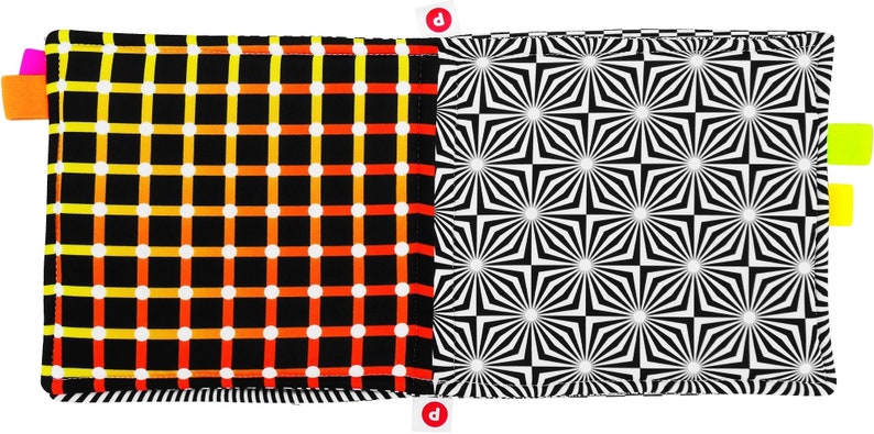 Puede incluir: Dos cuadrados de tela cosidos juntos para crear un panel de tela reversible. Un lado presenta un fondo negro con un patr&oacute;n de cuadr&iacute;cula de l&iacute;neas naranja, amarillas y blancas y puntos blancos. El otro lado presenta un patr&oacute;n geom&eacute;trico en blanco y negro de estrellas repetidas.