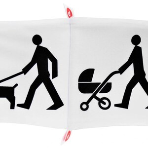 May include: A white pillow with black illustrations on each side. One side shows a person walking a dog on a leash. The other side shows a person pushing a stroller.