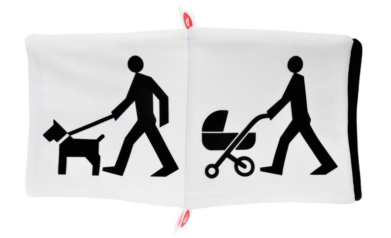 May include: A white pillow with black illustrations on each side. One side shows a person walking a dog on a leash. The other side shows a person pushing a stroller.